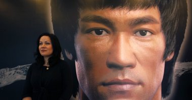 Shannon Lee, daughter of the late kung fu legend Bruce Lee, poses in front of a portrait of her father at the Hong Kong Heritage Museum, July 18, 2013. (REUTERS)