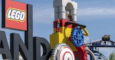 A roller coaster can be seen next to the Lego logo at the entrance to the Legoland amusement park in Guenzburg, southern Germany, Aug. 11, 2022. (dpa Photo via AP)