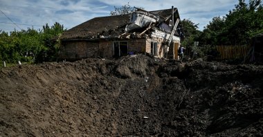 A man stands near a crater left by a Russian missile strike in the settlement of Kushuhum, in Zaporizhzhia region, Ukraine, Aug. 10, 2022. (Reuters Photo)