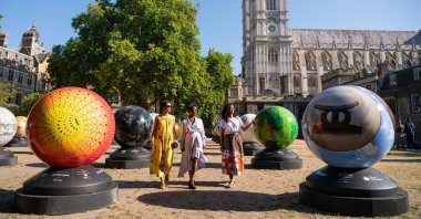 Londoner Selina Jones, Exhibition Artistic Director Lady Ashley Shaw Scott Adjaye and exhibition founder Michelle Gayle (L-R) view globe sculptures from "The World Reimagined," at Dean's Yard at Westminster Abbey, London, ahead of the launch of a new public art trail.