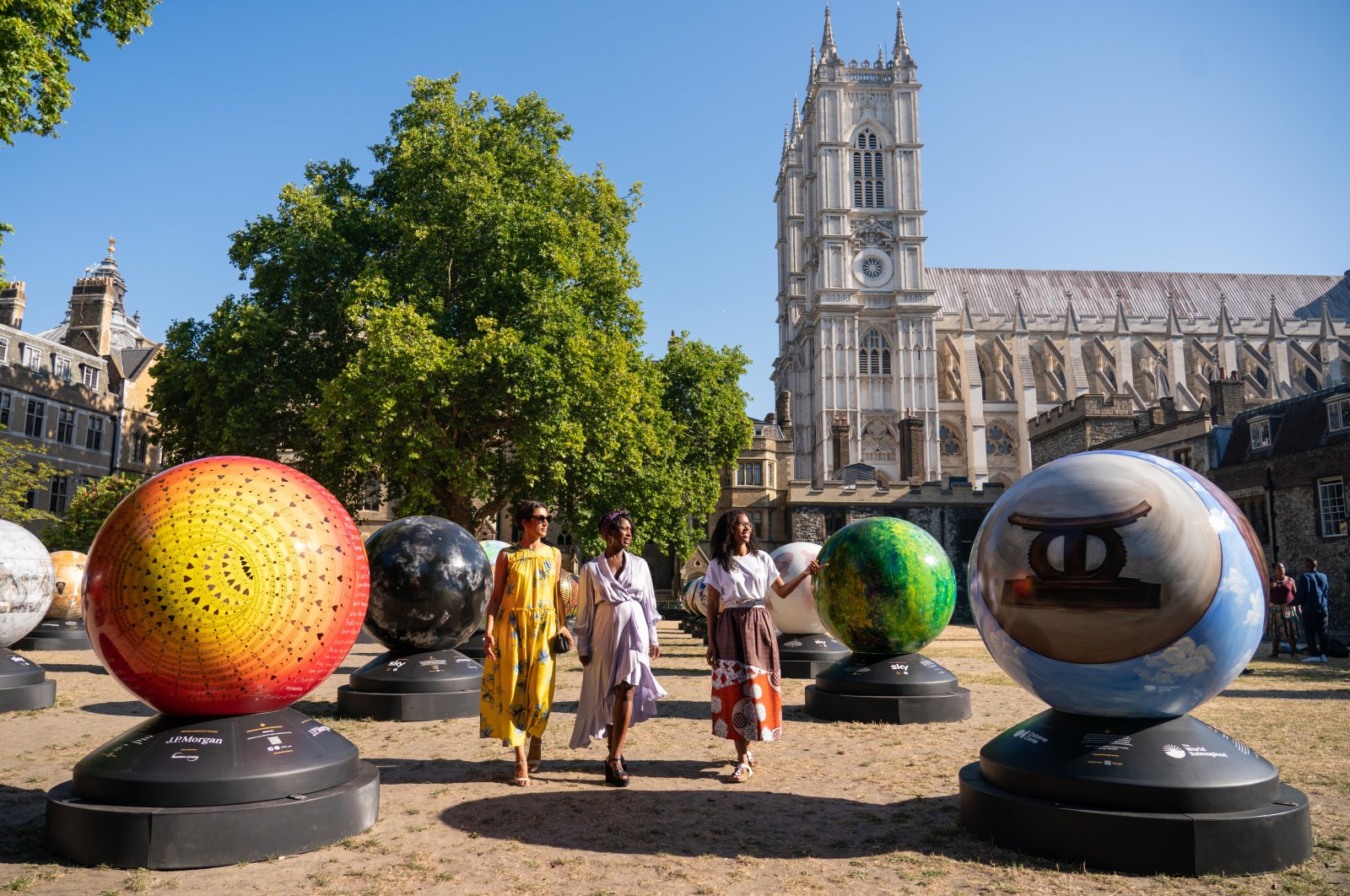 Londoner Selina Jones, Exhibition Artistic Director Lady Ashley Shaw Scott Adjaye and exhibition founder Michelle Gayle (L-R) view globe sculptures from &quot;The World Reimagined,&quot; at Dean&#039;s Yard at Westminster Abbey, London, ahead of the launch of a new public art trail.