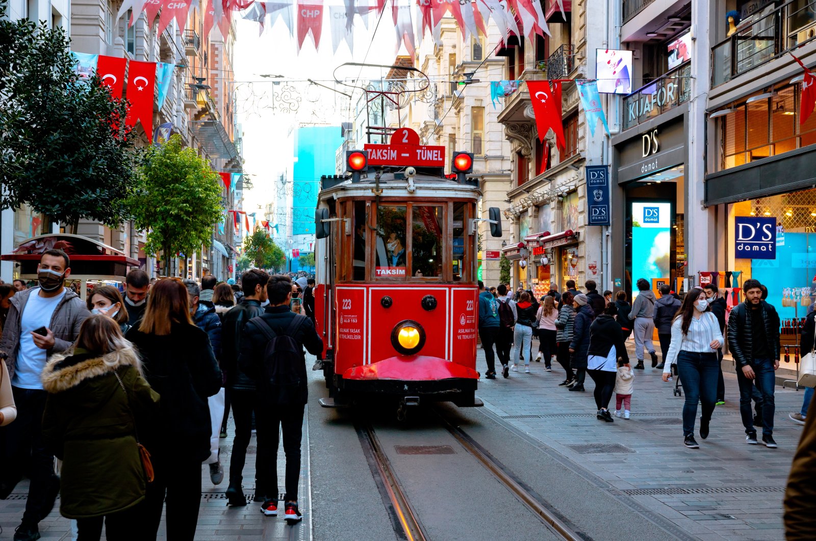 People walk down Istiklal Avenue as a tram passes through in Istanbul, Türkiye, Nov. 13, 2021. (Shutterstock Photo)