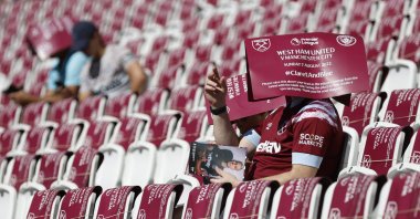 West Ham United fans sit with banners on their heads inside London Stadium before the match between West Ham United and Manchester City, London, Britain, Aug. 7, 2022. (Reuters Photo)