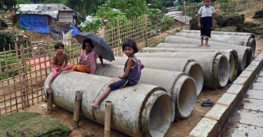Rohingya refugee children sit on pipes at Kutupalong refugee camp in Ukhia, Bangladesh, Aug. 14, 2022. (AFP Photo)