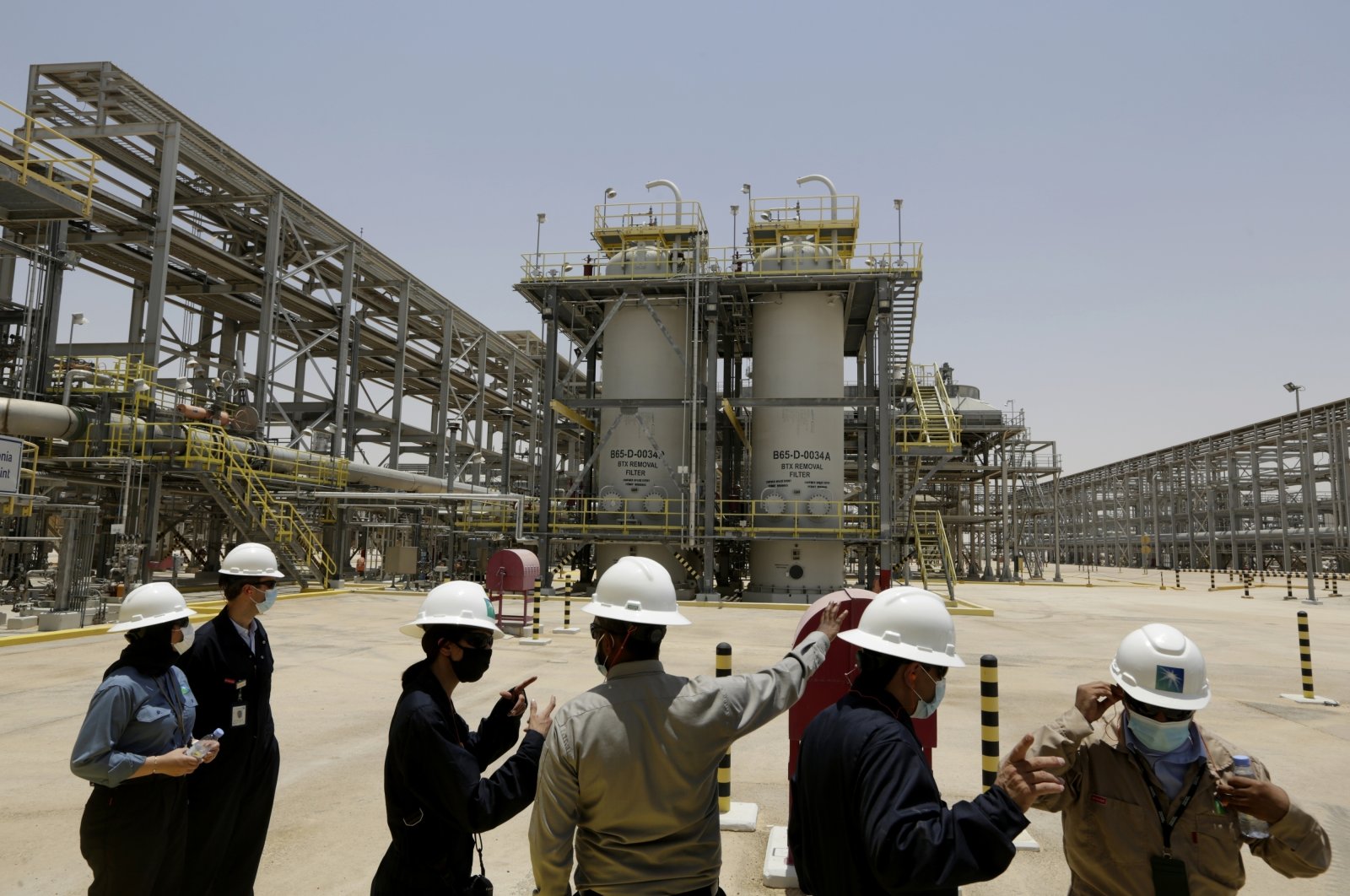 Saudi Aramco engineers and journalists look at the Hawiyah Natural Gas Liquids Recovery Plant in Hawiyah, in eastern Saudi Arabia, June 28, 2021. (AP Photo)