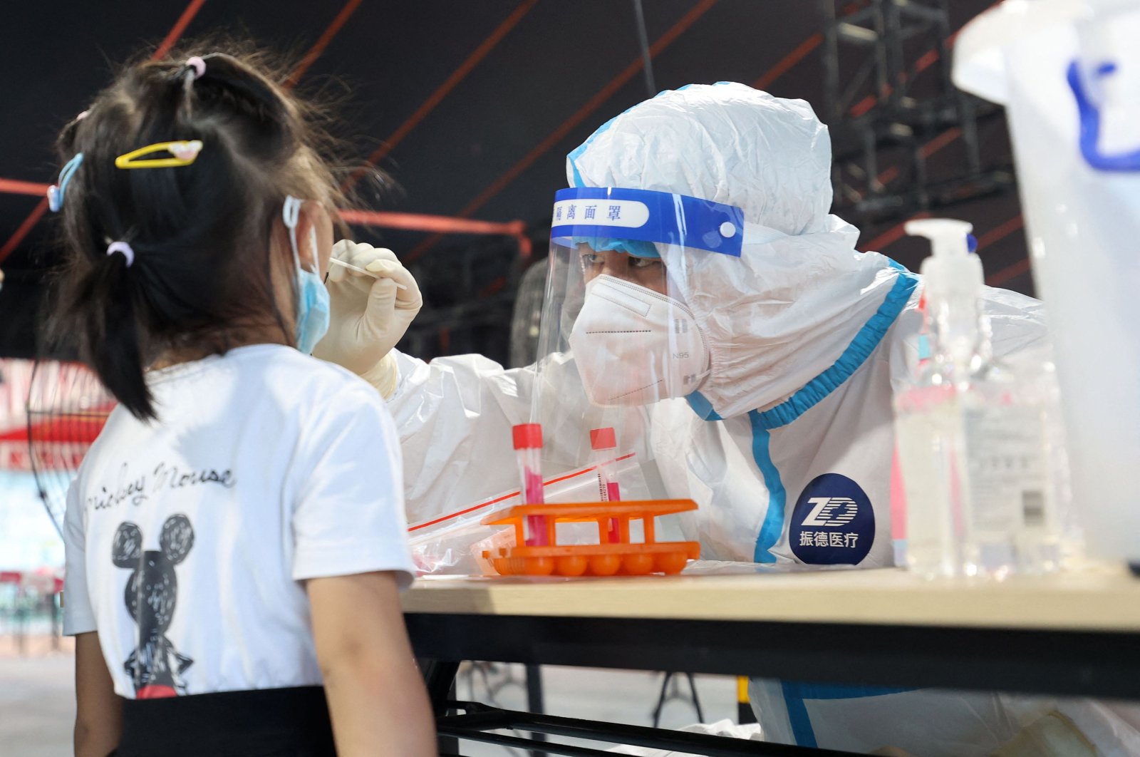 A health worker conducting a swab test on a child for the COVID-19 coronavirus in Xiamen, China, August 10, 2022. (AFP Photo)