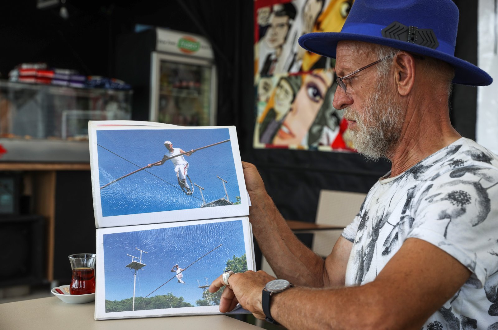 Özdemir Turan shows his photos of tightrope walking, in Istanbul, Türkiye, Aug. 14, 2022. (AA Photo)