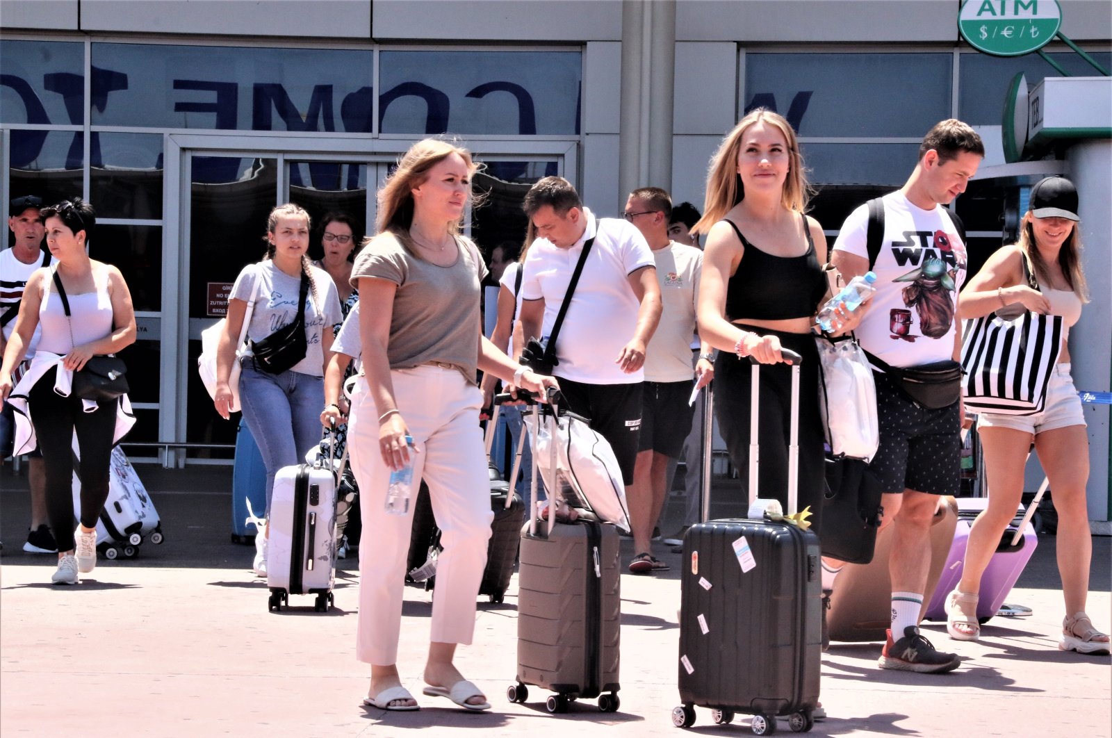 Tourists exit an airport as they arrive in Antalya, one of the most popular tourist destinations in the Mediterranean, southern Türkiye, Aug. 11, 2022. (IHA Photo)
