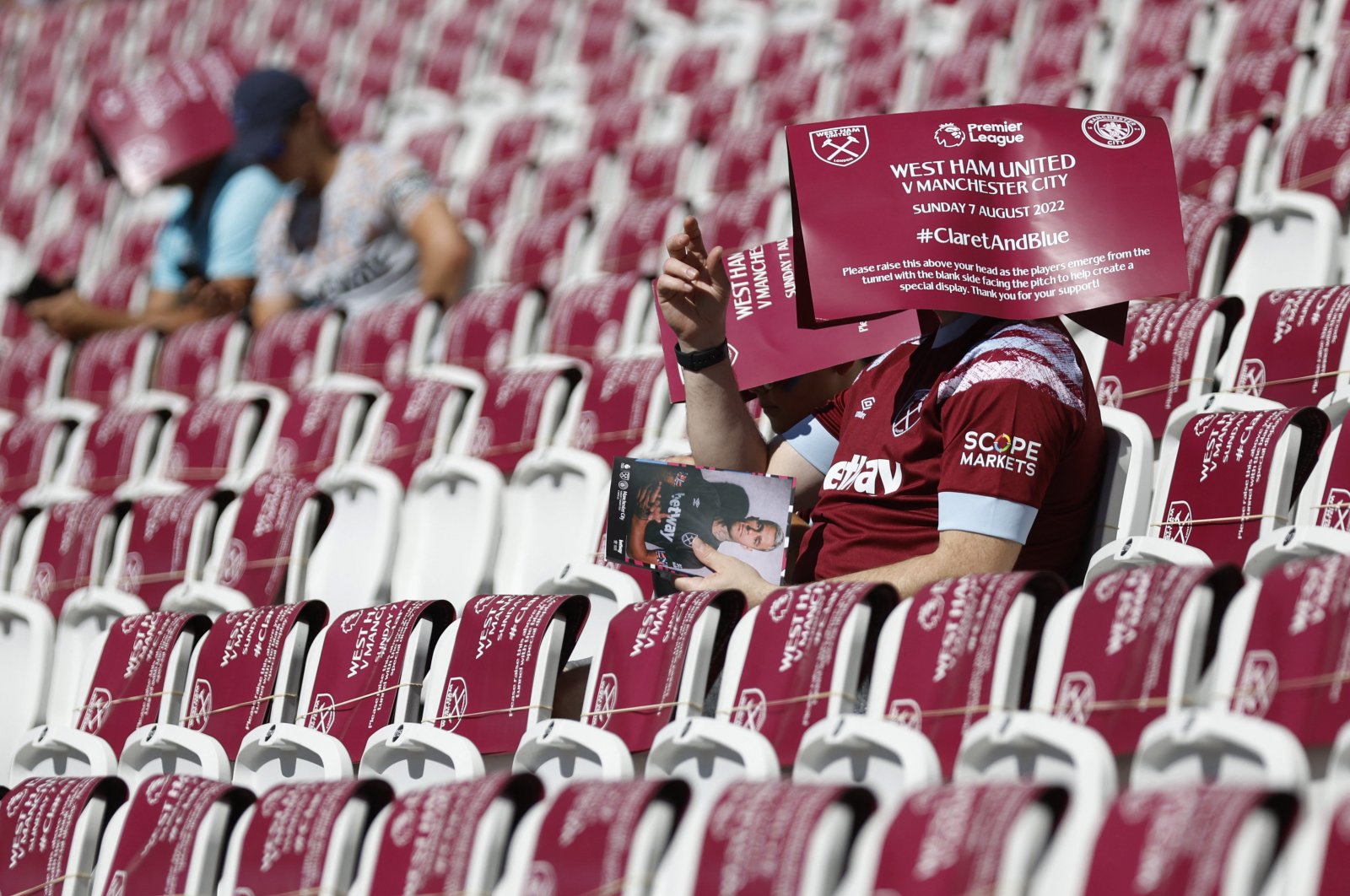 West Ham United fans sit with banners on their heads inside London Stadium before the match between West Ham United and Manchester City, London, Britain, Aug. 7, 2022. (Reuters Photo)