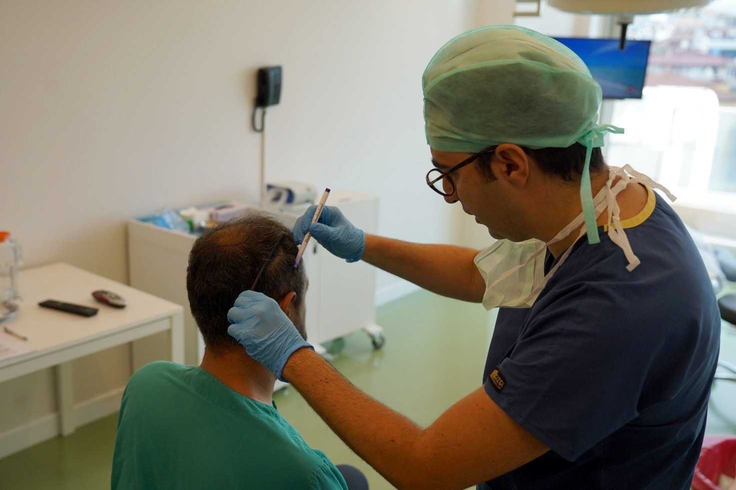 Dr. Ali Emre Karadeniz examines the head of a transplant recipient, in Istanbul, Türkiye, Aug. 14, 2022. (Photo by Mevlüt Hasgül)
