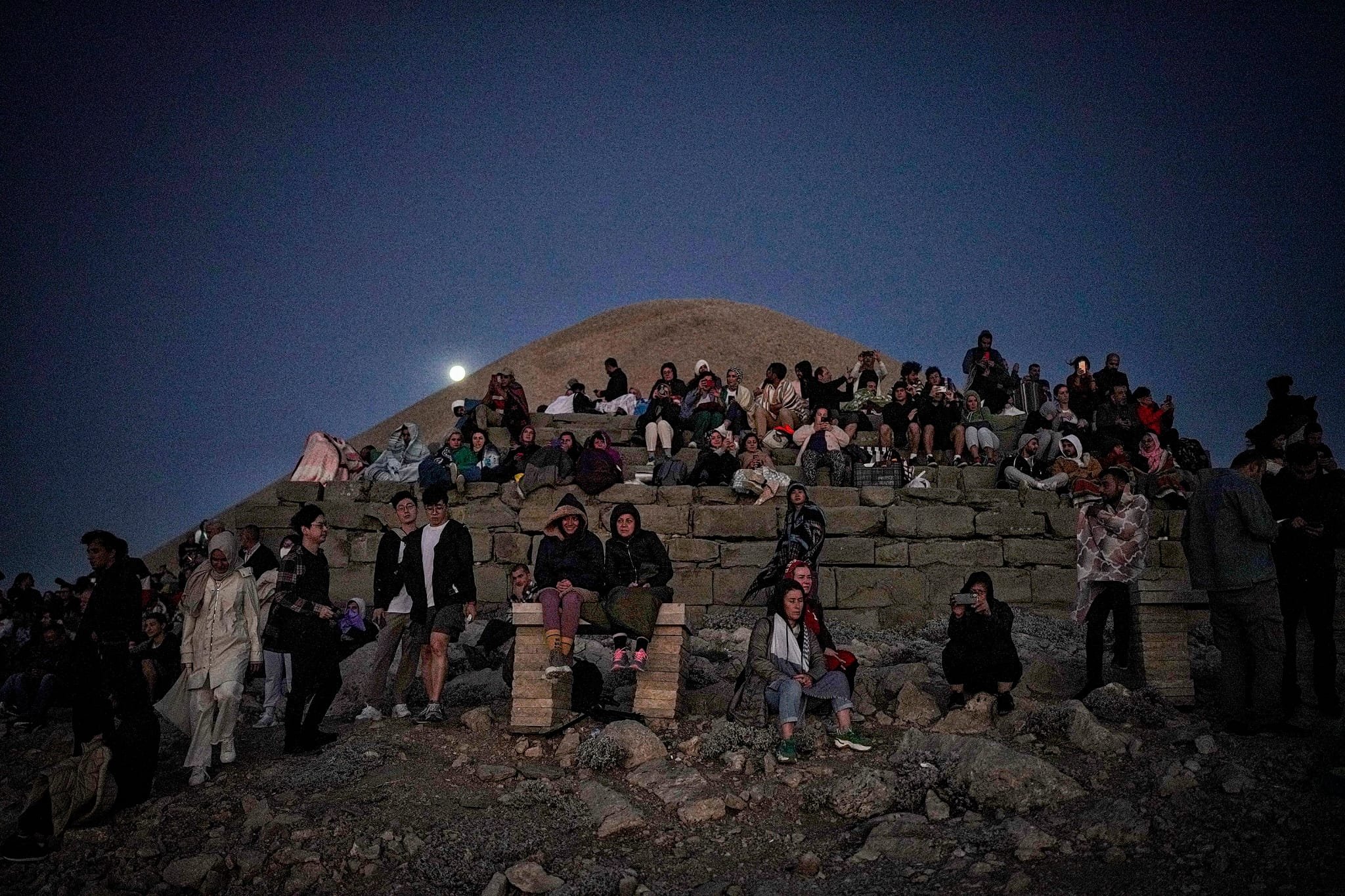Orang-orang menyaksikan langit malam di Gunung Nemrut, Adıyaman, Türkiye, 11 Agustus 2022. (Foto oleh Uğur Yıldırım)