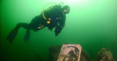 A diver swims past a stone carving of Türkiye's first President Atatürk, in Gölcük, Kocaeli, northwestern Türkiye, Aug. 15, 2022. (DHA Photo)