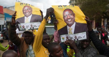 Supporters hold posters of William Ruto, Kenya's deputy president and presidential candidate of the Kenya Kwanza (Kenya First) political party coalition, as they gather while waiting for the results of Kenya's general election in Eldoret, Kenya, Aug. 15, 2022. (AFP Photo)