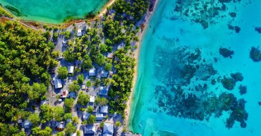 An aerial photo of turquoise lagoon with vibrant island village. (ShutterStock Photo)