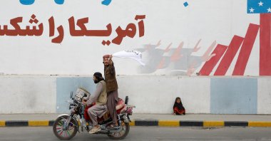 A Taliban supporter holds an Islamic Emirate of Afghanistan flag on the first anniversary of the fall of Kabul on a street in Kabul, Afghanistan, Aug. 15, 2022. (Reuters Photo)