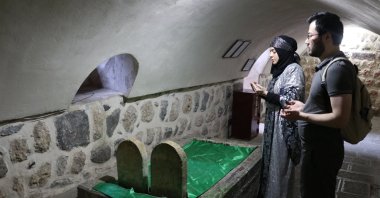 The couple recites prayers at the tomb of Mem and Zin, in Cizre, Şırnak, southeastern Türkiye, Aug. 15, 2022. (AA PHOTO) 