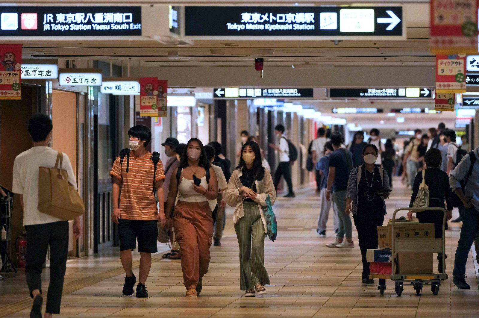 People stroll in an underground shopping mall in Tokyo, Japan, Aug. 15, 2022. (AFP Photo)