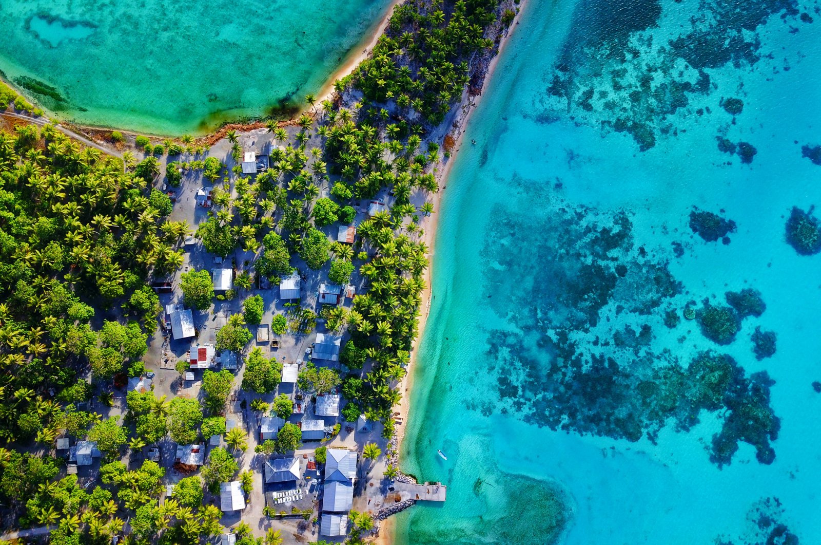An aerial photo of turquoise lagoon with vibrant island village. (ShutterStock Photo)