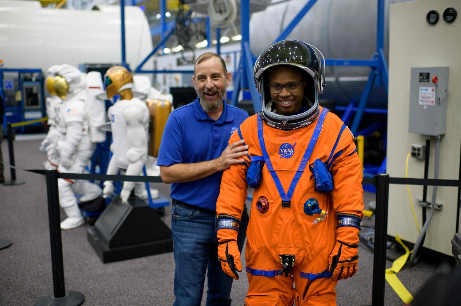 Suit technicians Bill Owens (L) and Henry Phillips laugh while showing off a spacesuit at the Johnson Space Center’s Space Vehicle Mock-up Facility in Houston, Texas, U.S., Aug. 5, 2022. (AFP Photo)