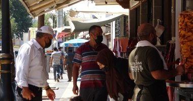 People wearing protective masks walk on a street in Diyarbakır, southeastern Türkiye, Aug. 14, 2022. (İHA PHOTO)