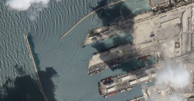 This satellite image from Planet Labs PBC shows the Sierra Leone-flagged cargo ship Razoni, center bottom with four white cranes on its red deck, at port in Tartus, Syria, Aug. 15, 2022. The first shipment of grain to leave Ukraine under a wartime deal has ended up in Syria, even as that country remains a close ally of Moscow, satellite images analyzed Tuesday by The Associated Press show. (Planet Labs PBC via AP)