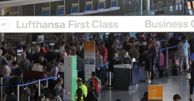 A sign for Lufthansa is seen as passengers wait and queue in front of counters for departure at Frankfurt Airport, Frankfurt am Main, Germany, July 27, 2022. (AFP File Photo)