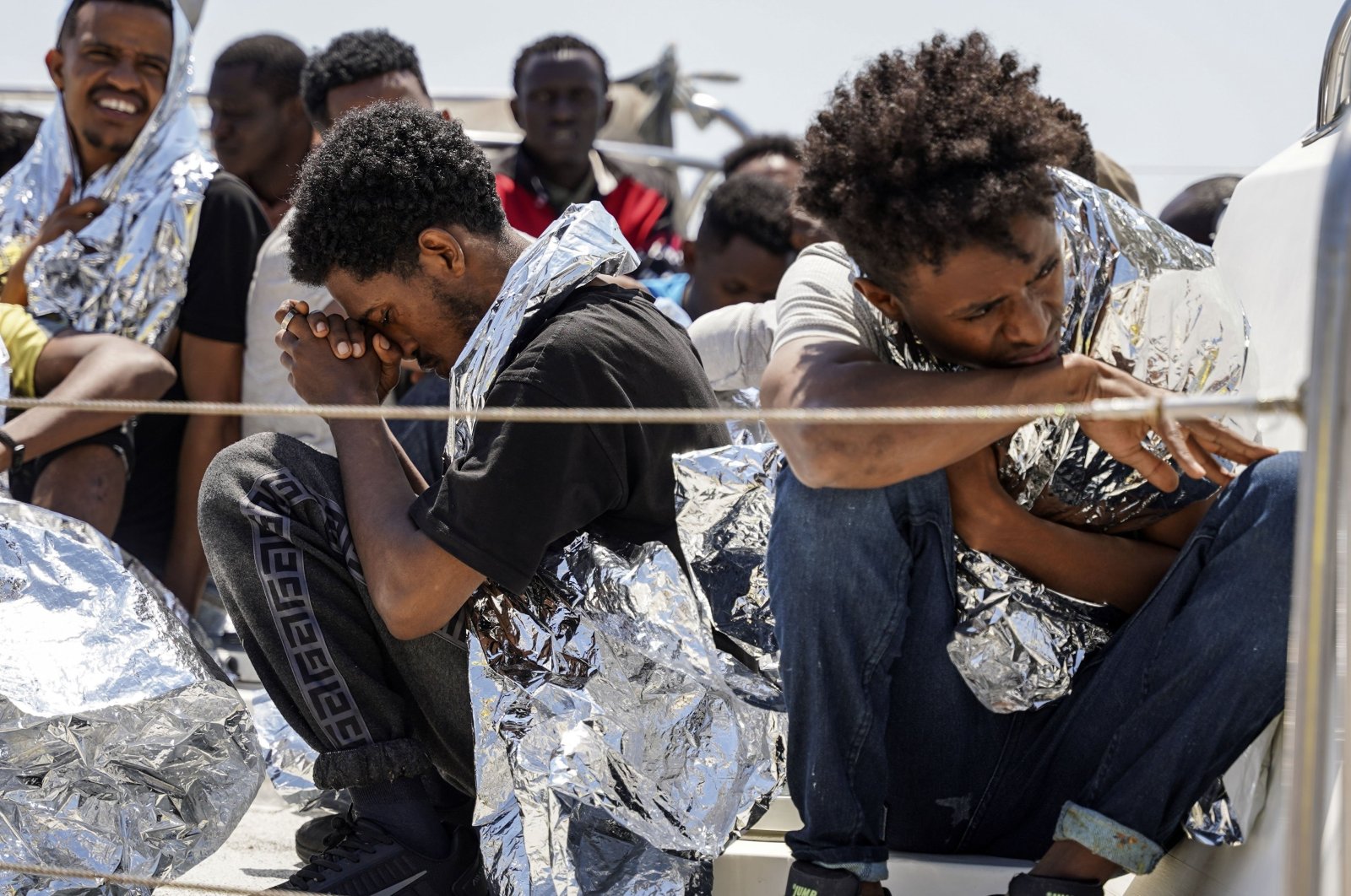 Migrants sit on the deck of a coast guard vessel upon their arrival at Mytilene port, on the northeastern Aegean Sea island of Lesbos, Greece, June 22, 2022. (AP Photo)