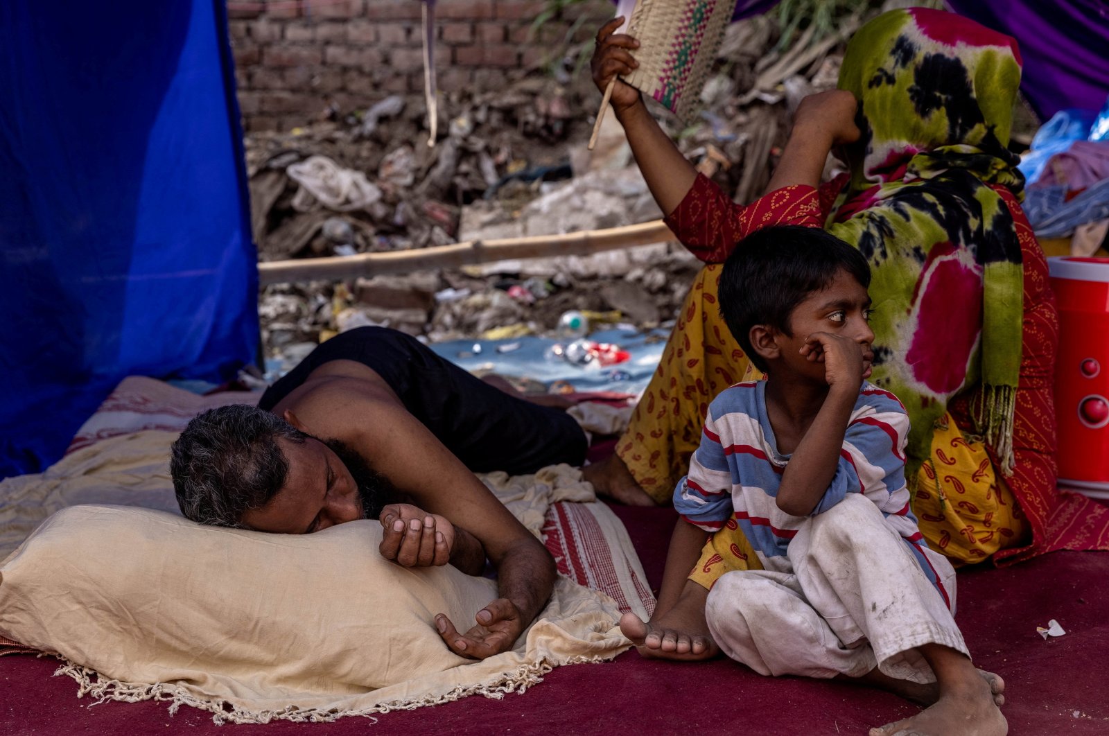 A Rohingya refugee family rests in a temporary shelter after a fire destroyed a Rohingya refugee camp, in New Delhi, India, June 14, 2021 (Reuters Photo)