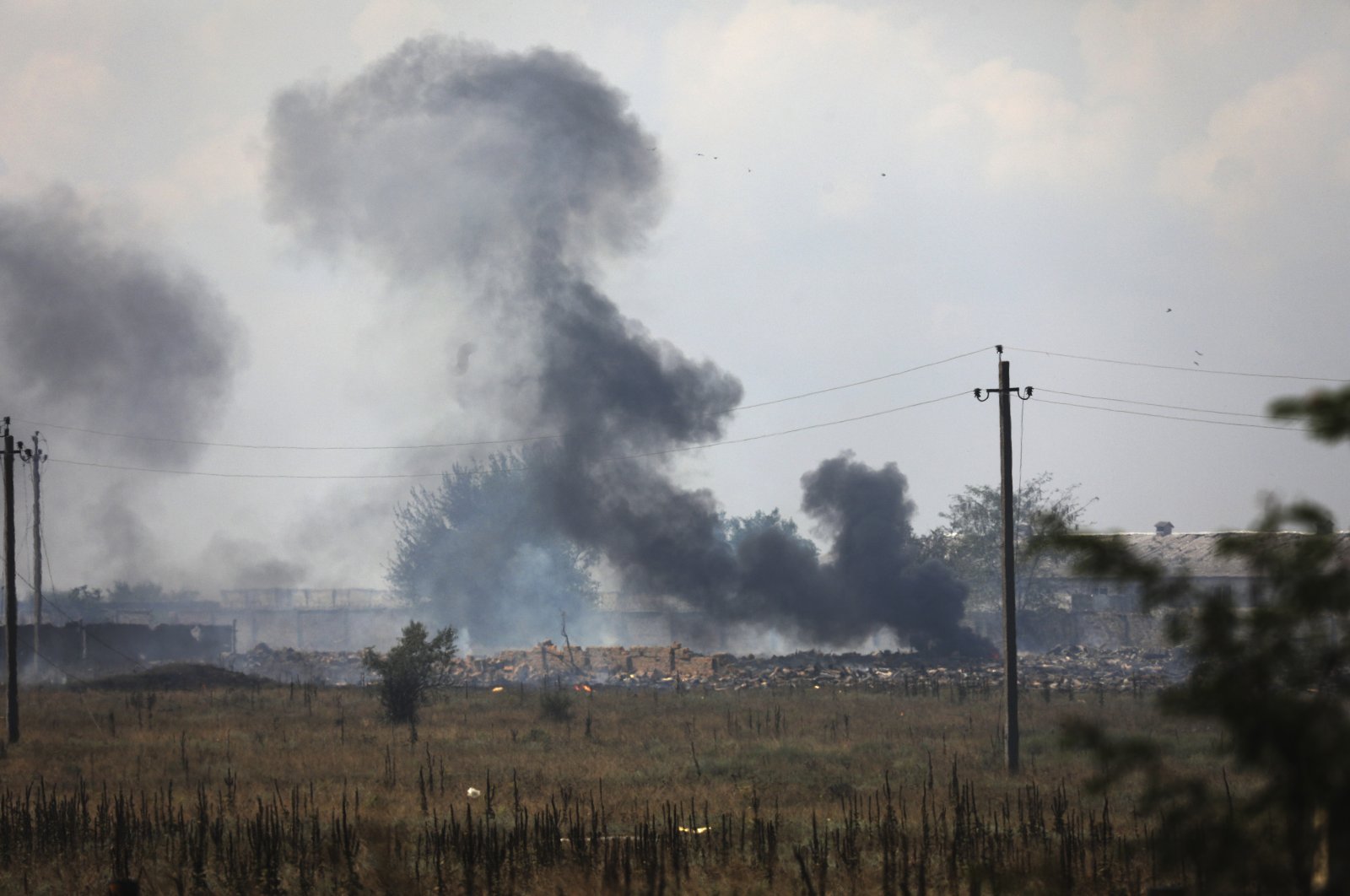 Smoke rises over the site of an explosion at a Russian ammunition storage facility near the village of Mayskoye, Crimea, Aug. 16, 2022. (AP Photo)