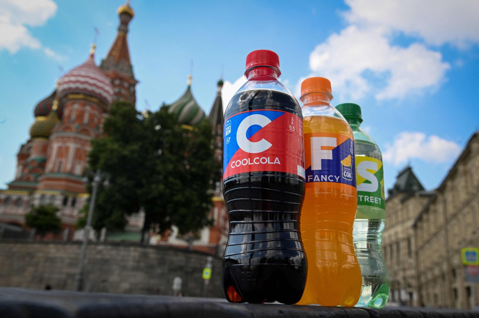 Bottles of soft drinks CoolCola, Fancy and Street, with their names and designs resembling Coca-Cola, Fanta and Sprite – the iconic brands of U.S. beverage giant Coca-Cola, are pictured in front of St. Basil&#039;s Cathedral in downtown Moscow, Russia, July 25, 2022. (AFP Photo)