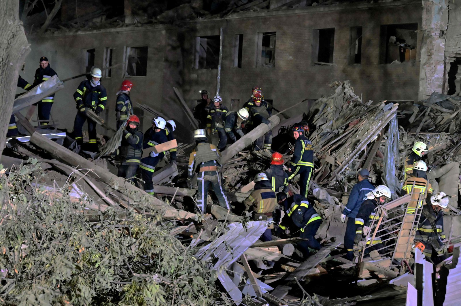 Rescue workers inspect the site of a destroyed hostel after a missile strike in Kharkiv, Ukraine, Aug. 17, 2022. (AFP Photo)