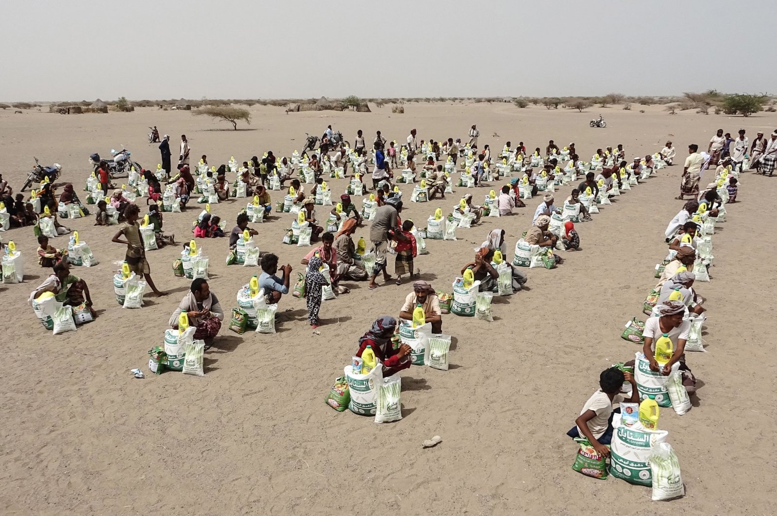 Yemenis displaced by the conflict receive food aid and supplies to meet their basic needs, at a camp in Hays district in the war-ravaged western province of Hodeida,  July 6, 2022. (AFP File Photo)