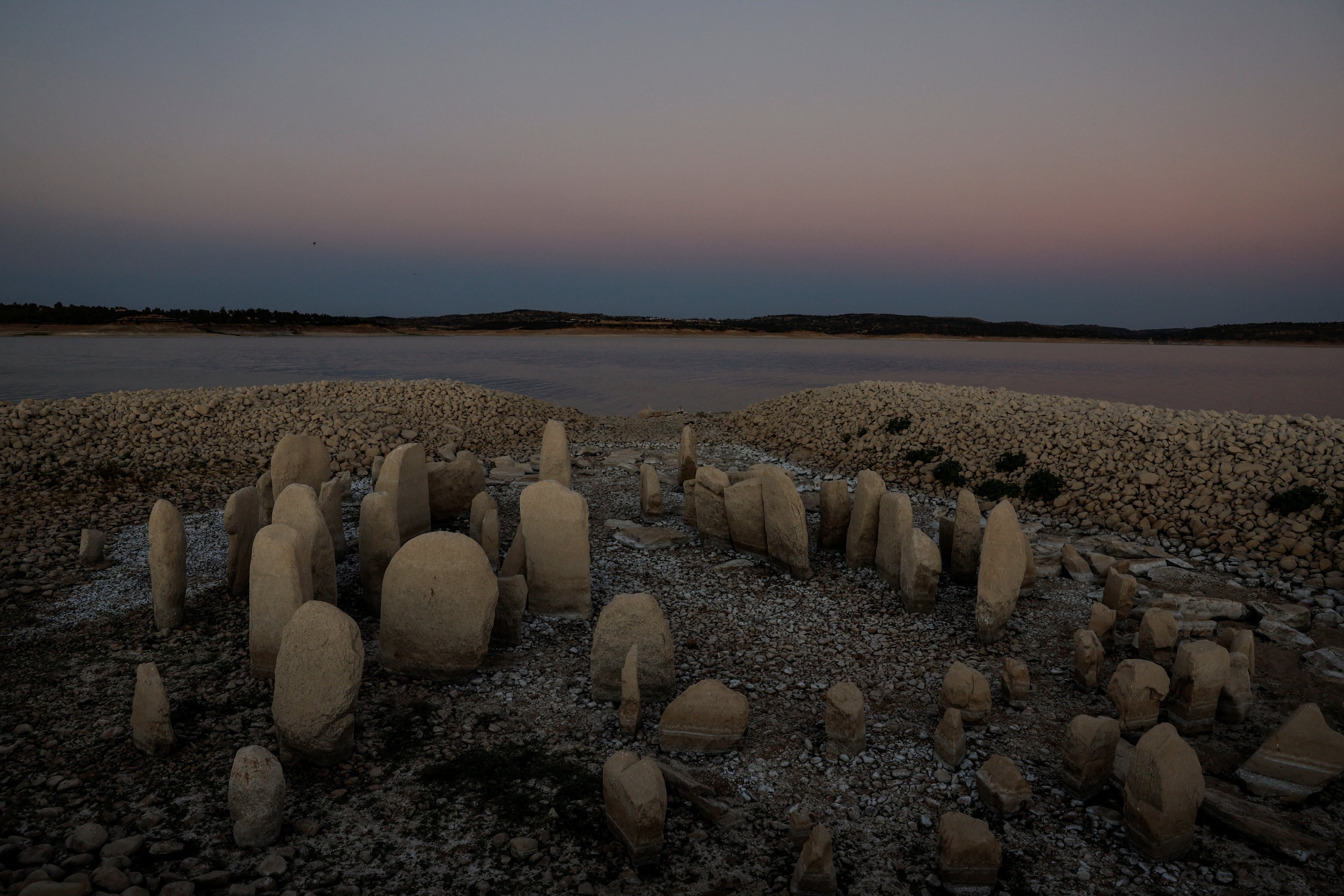 Dolmen Guadalperal, juga dikenal sebagai Spanish Stonehenge, muncul kembali setelah air surut di reservoir Valdecanas di pinggiran El Gordo, Spanyol, 3 Agustus 2022. (Foto Reuters)