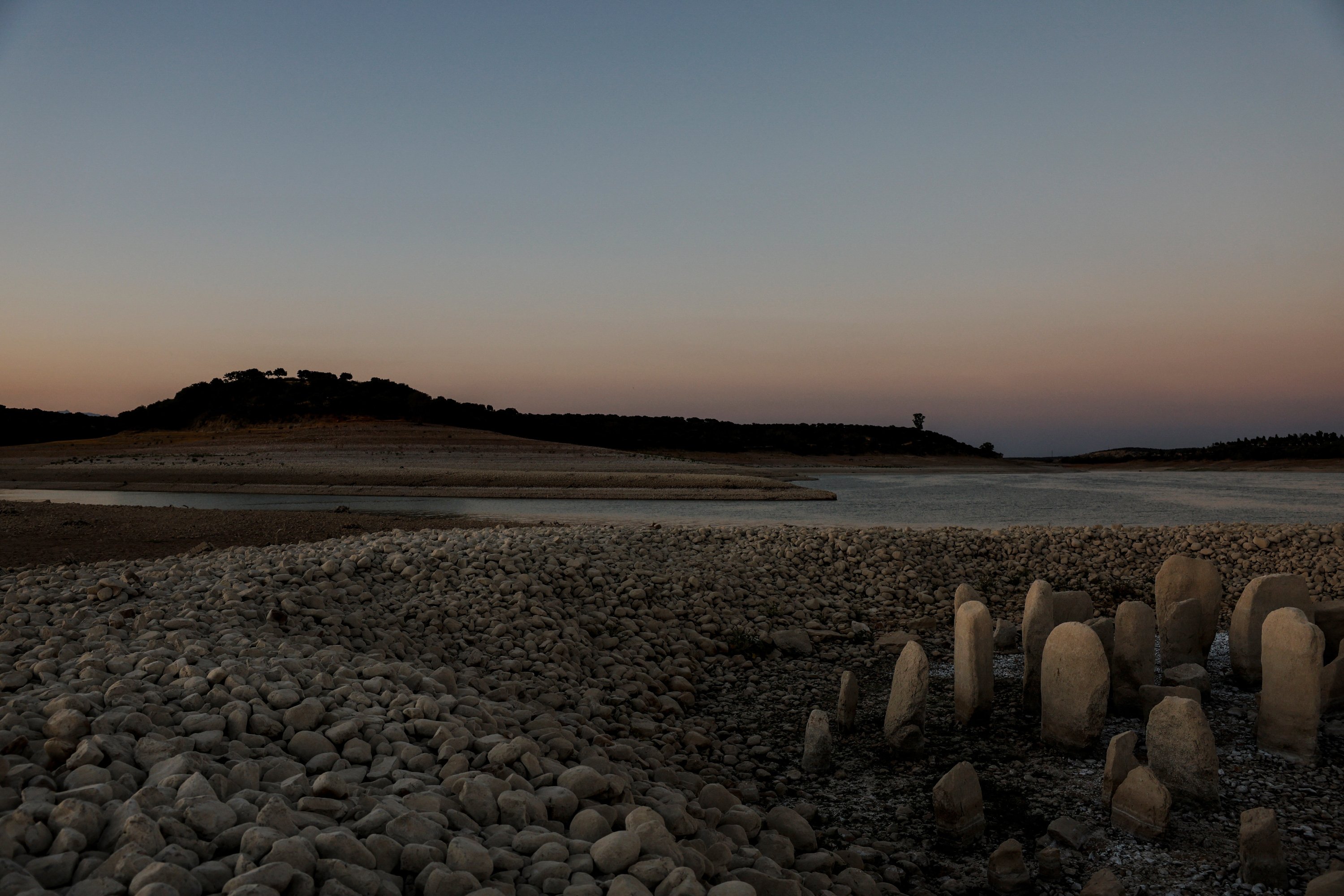 Dolmen Guadalperal, juga dikenal sebagai Spanish Stonehenge, muncul kembali setelah air surut di reservoir Valdecanas di pinggiran El Gordo, Spanyol, 3 Agustus 2022. (Foto Reuters)