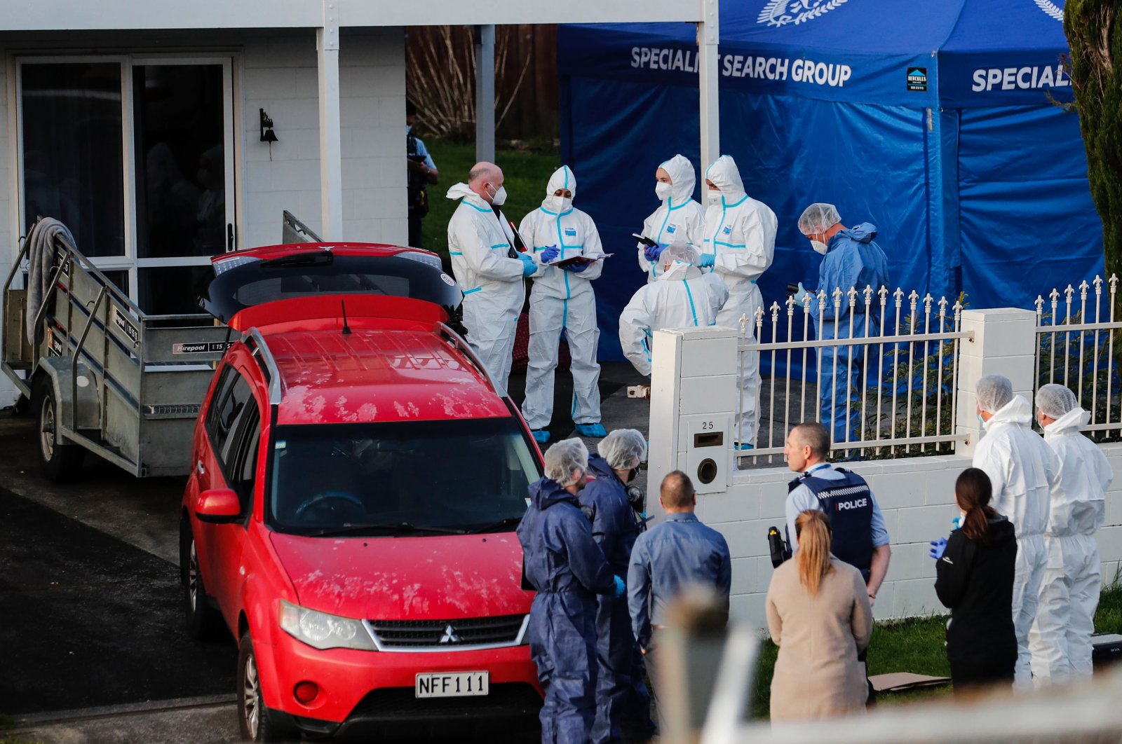 New Zealand police investigators work at a scene after bodies were discovered in suitcases, in Auckland, New Zealand, Aug. 11, 2022. (New Zealand Herald via AP)