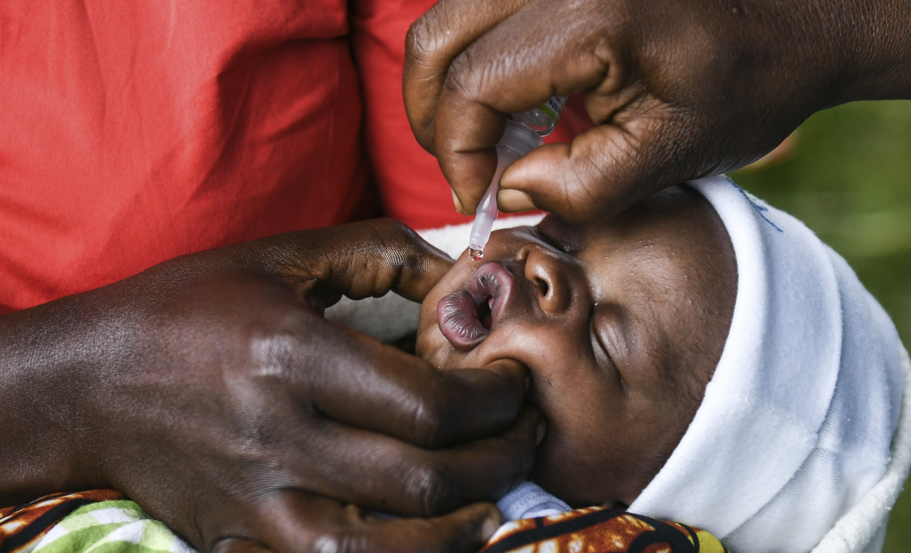Seorang bayi menerima vaksin polio oral selama Peluncuran Kampanye Vaksinasi Polio Malawi di Lilongwe, Malawi, 20 Maret 2022. (AP Photo)