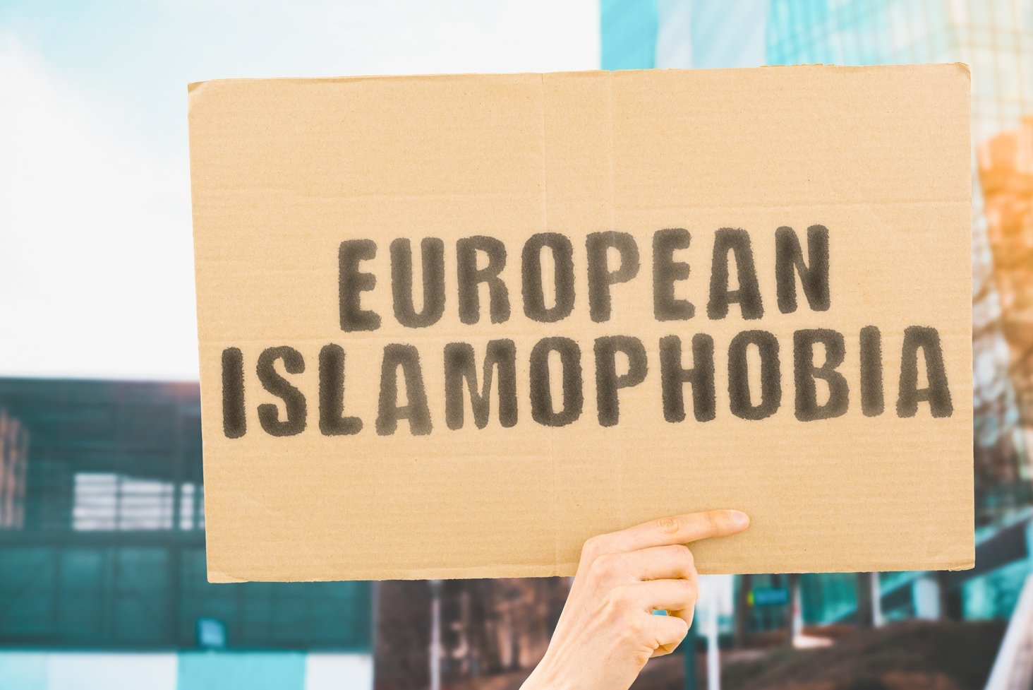The phrase &quot;European Islamophobia&quot; on a banner in a men&#039;s hand. (Shutterstock)