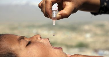 An Afghan health worker uses an oral polio vaccine on a child as part of a campaign to eliminate polio, on the outskirts of Kabul, Afghanistan, April 18, 2017. (AP Photo)