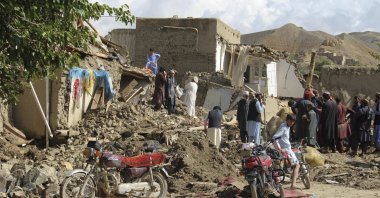 People clean up their damaged homes after heavy flooding in the Khushi district of Logar province south of Kabul, Afghanistan, Aug. 21, 2022. (AP Photo)