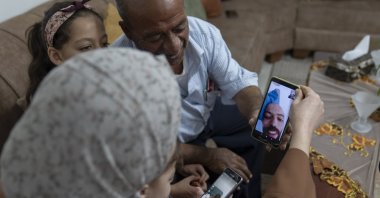 Khalil Awawdeh, a Palestinian detainee in Israel, talks to family members on a video call, at their family house in the West Bank village of Idna, Hebron, Monday, Aug. 22, 2022. (AP Photo)