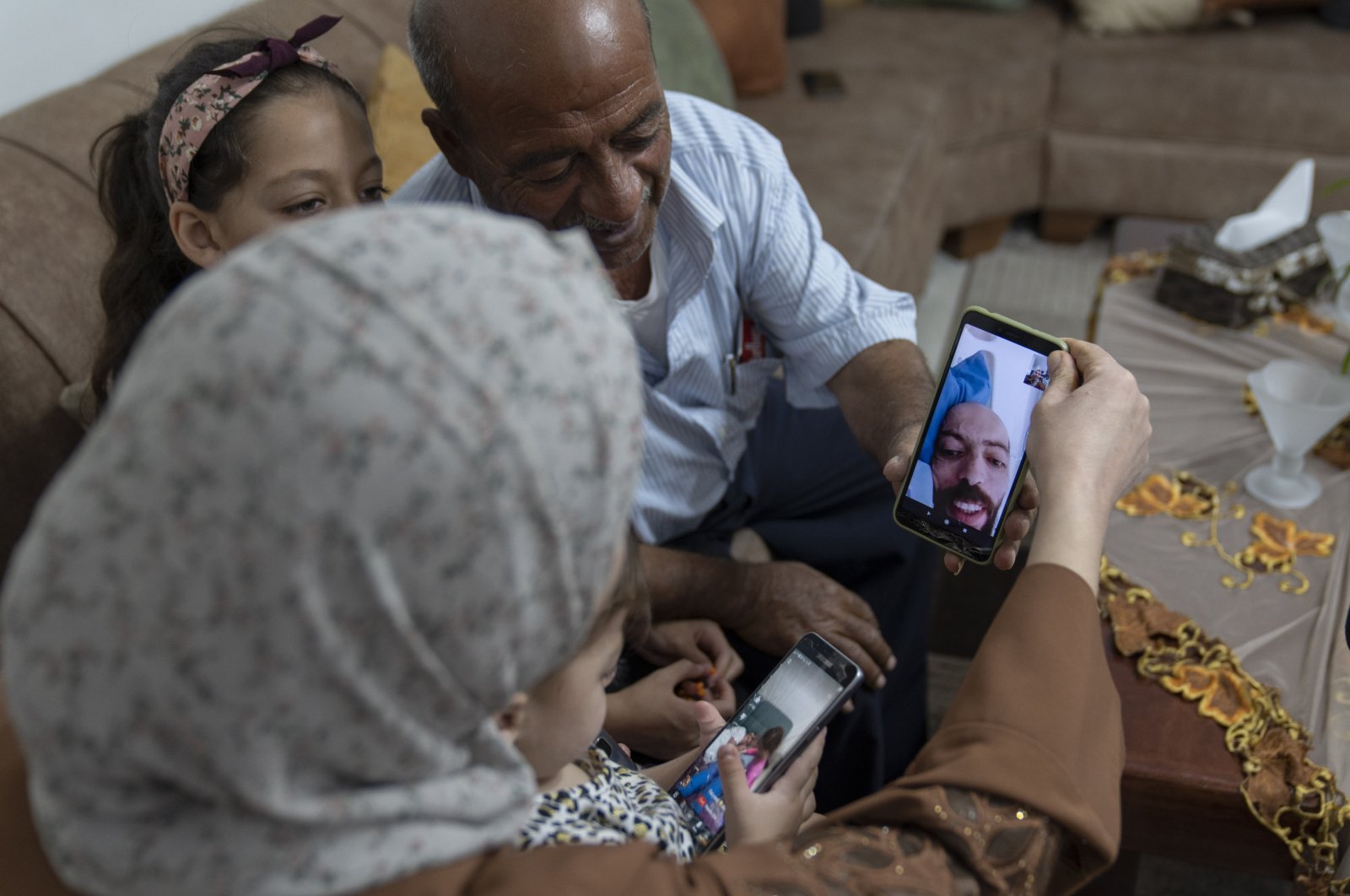 Khalil Awawdeh, a Palestinian detainee in Israel, talks to family members on a video call, at their family house in the West Bank village of Idna, Hebron, Monday, Aug. 22, 2022. (AP Photo)