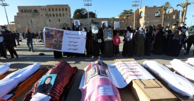 Mourners show portraits near bodies that were exhumed from a mass grave in Tarhuna, Libya, Jan. 22, 2021. (Reuters Photo)