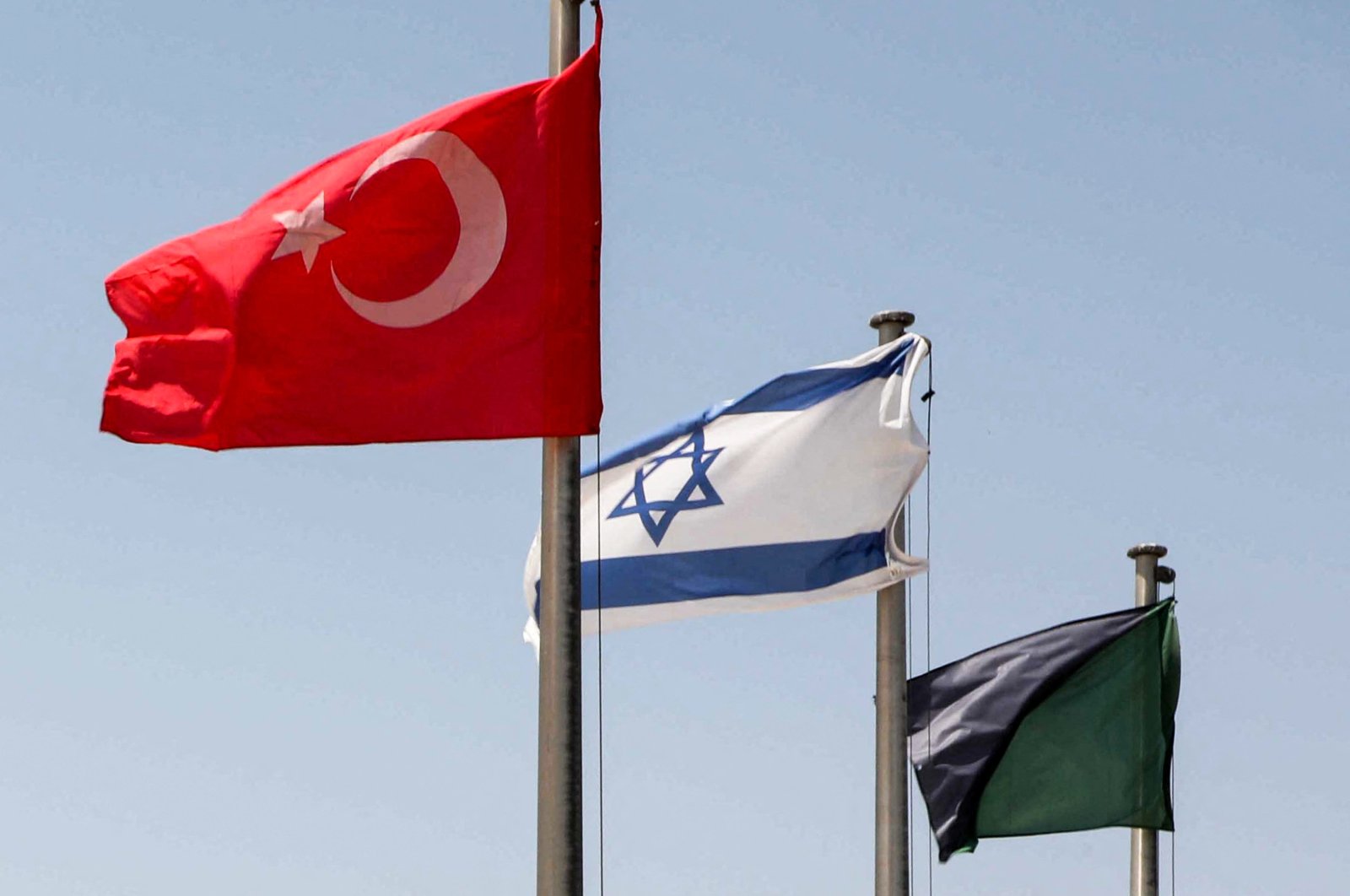 The flags of Türkiye (L) and Israel (C) fly at a war memorial in Latrun, about 30 kilometers west of Jerusalem, Israel, Aug. 18, 2022. (AFP)