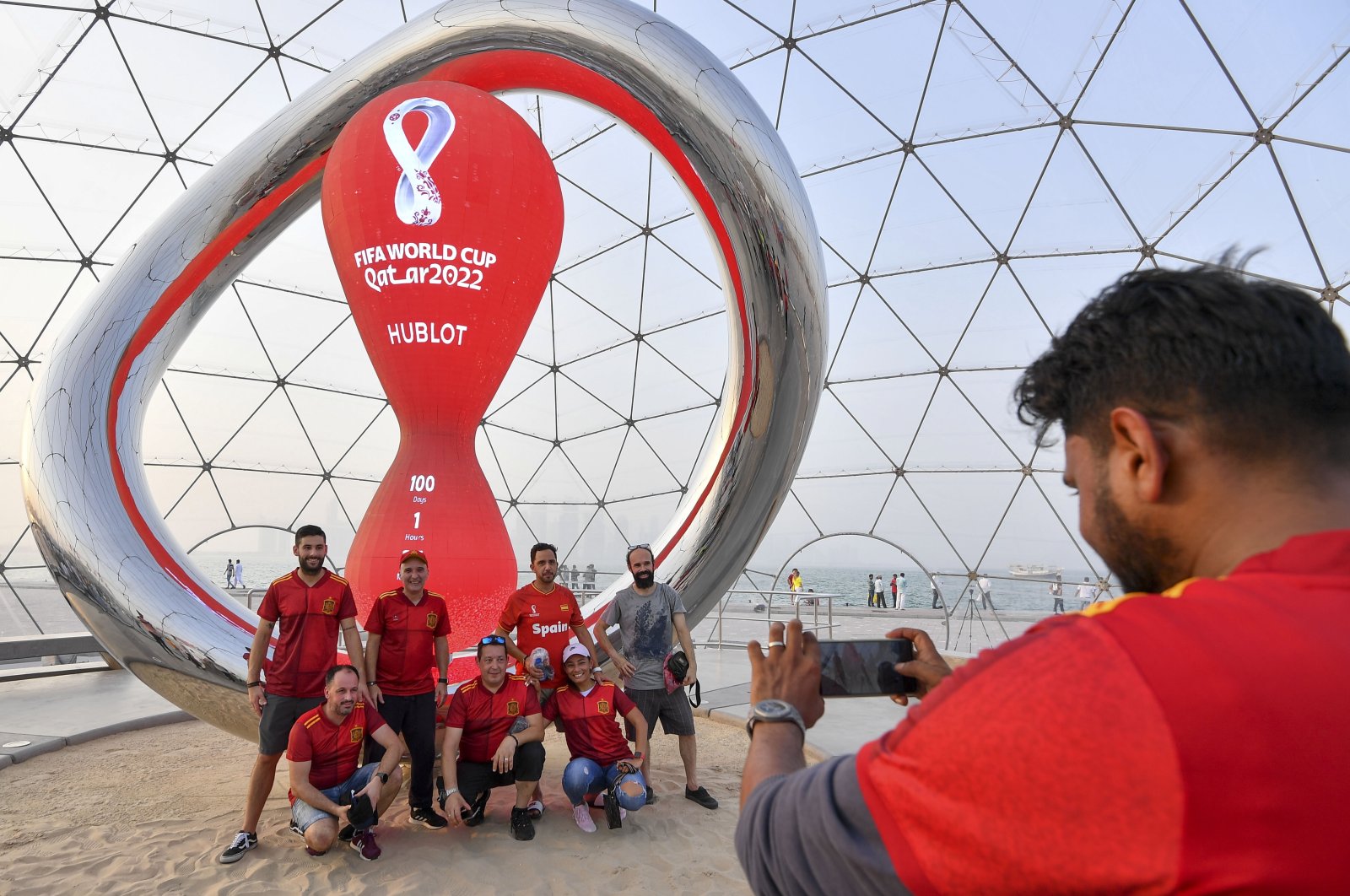 Football fans pose in front of the Qatar 2022 FIFA World Cup countdown clock, Doha, Qatar, Aug. 12, 2022. (EPA Photo)