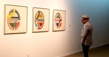 A visitor looks at &quot;Sinjerli Variations I-V,&quot; by American painter Frank Stella in 1977, during the &quot;Minimalism and Conceptual Art&quot; exhibition, which showcases works from the 19th and 20th centuries by American and European artists, at the Tehran Museum of Contemporary Art in the Iranian capital, Aug. 22, 2022. (AFP)
