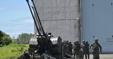 Taiwanese soldiers stand beside a Swiss-made GDF-006 anti-aircraft gun during during a media event at Hualien Air Force Base on Aug. 18, 2022. (Photo by Sam Yeh / AFP)