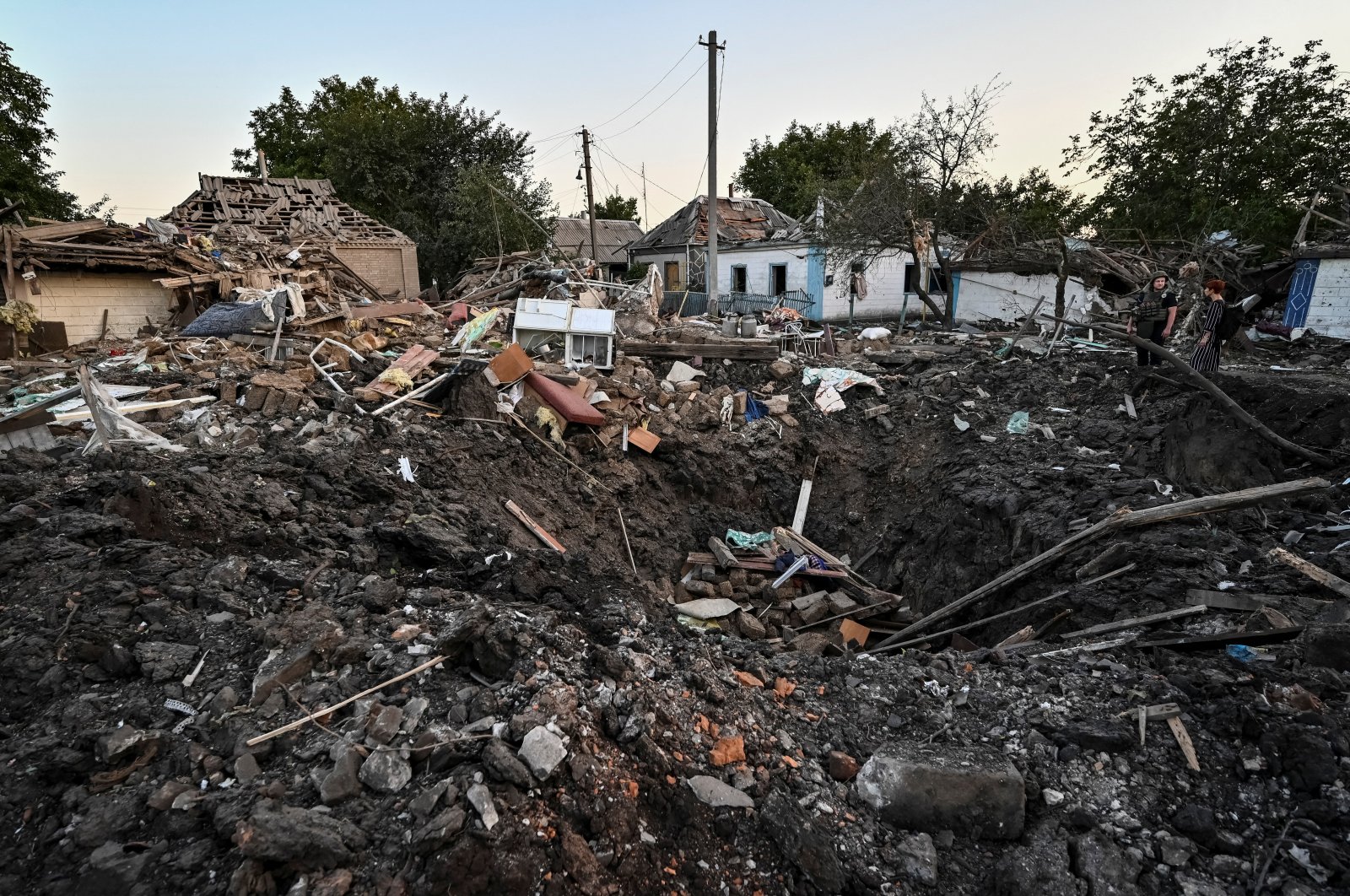 People stand next to a residential house destroyed by a Russian military strike in Chaplyne, Dnipropetrovsk region, Ukraine, Aug. 24, 2022. (Reuters Photo)