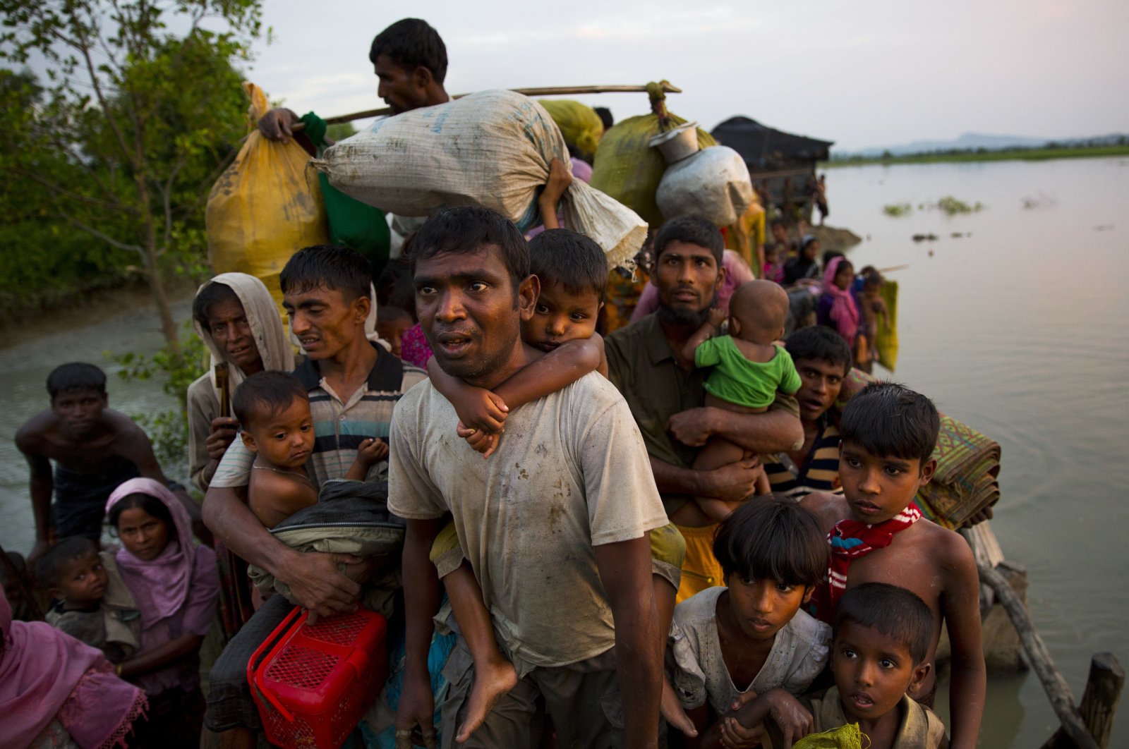 Rohingya Muslims carry their young children and belongings after crossing the border from Myanmar into Bangladesh, near Palong Khali, Bangladesh, Nov. 1, 2017. (AP Photo)