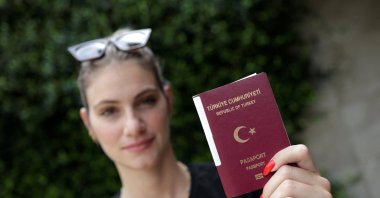 TV presenter Sinem Ökten holds her passport during an interview in Istanbul, Türkiye, Aug. 24, 2022. (Reuters Photo)