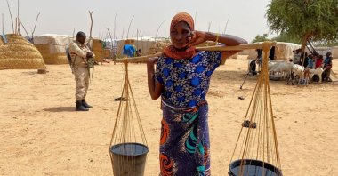 A woman carrying water poses for a photo in a camp for displaced people in the town of Ouallam, Niger, July 6, 2021. (Reuters Photo)